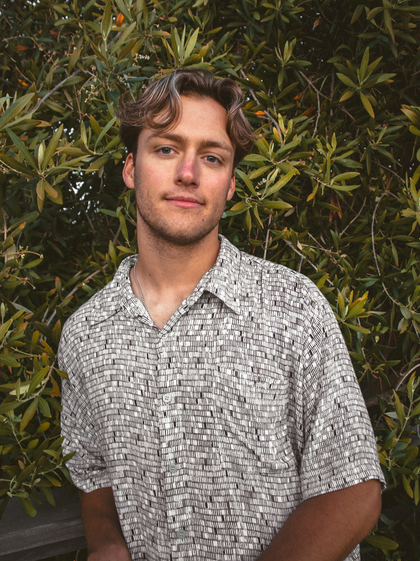 Cade in patterned collared shirt smiling