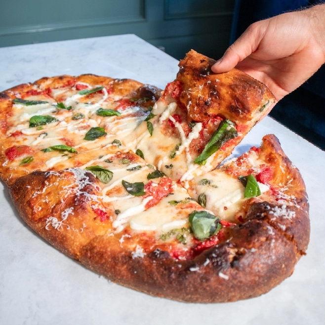 Person grabbing slice of pizza