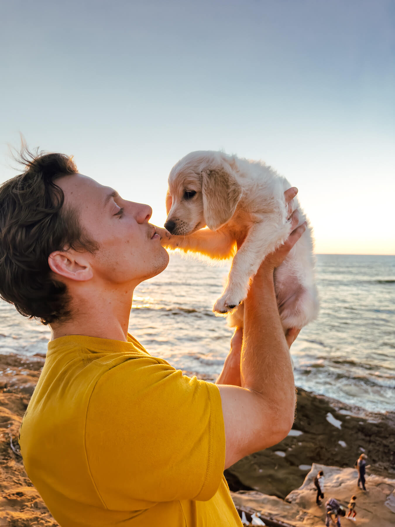 Person holding puppy in air